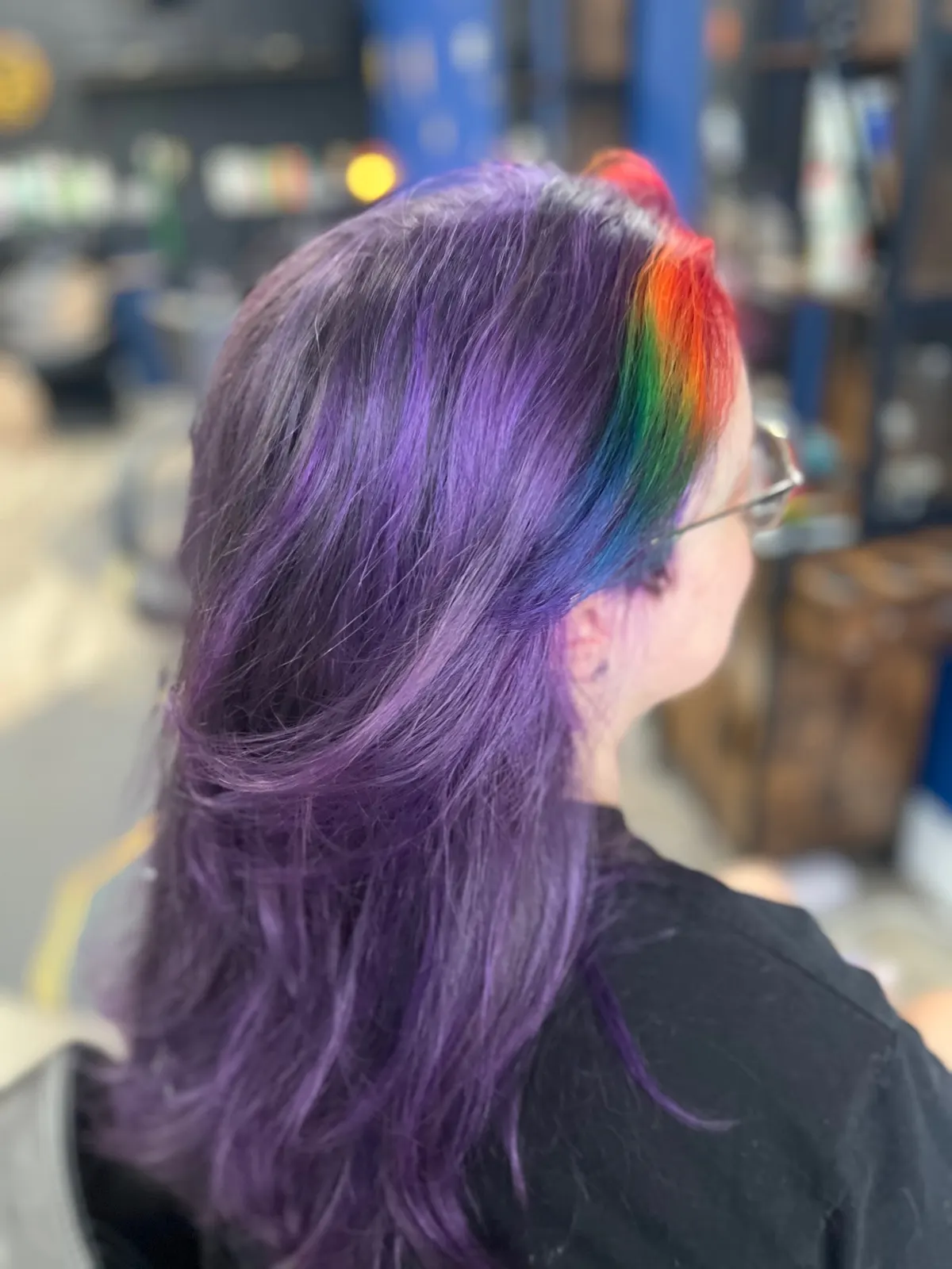 Sleek purple hair with a bold rainbow front section, vivid color by Gray