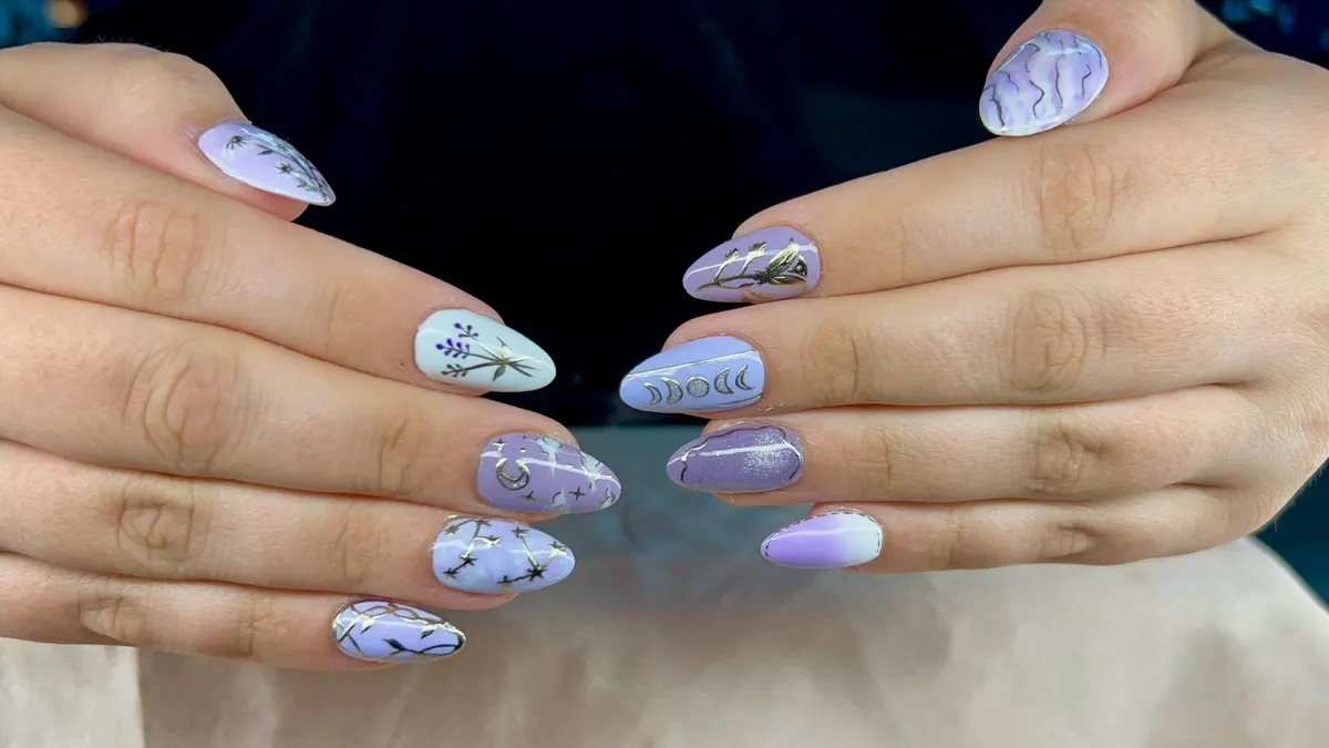 Lilac celestial moon-phase nail set with stars and lavender sprigs, by Victoria